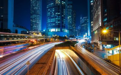 Traffic on a busy highway at night time with an urban landscape background